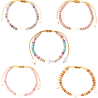 Bracelet sur corde réglable grains de forme cylindrique avec croix et coeur en coquille naturelle.