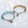 Bracelet dizainier sur chaine, grains en semi-cristal de Ø 6 mm avec medaille miraculeuse. Differentes couleurs